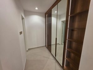 Walk-in closet with built-in wooden wardrobes and mirror doors in a renovated villa in Jumeirah 3 Dubai